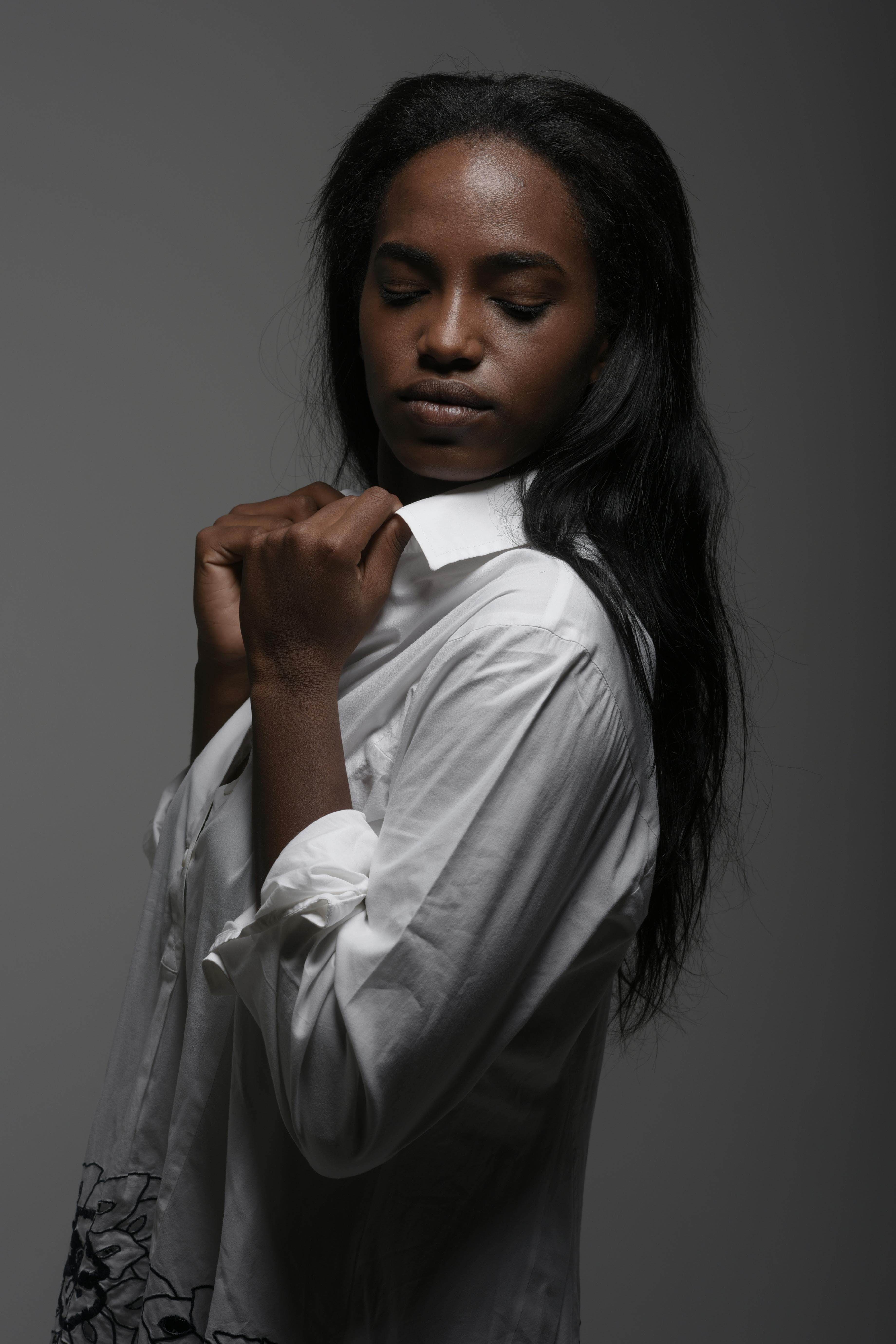 La Chemise Écrue — portrait de studio sur fond sombre.
